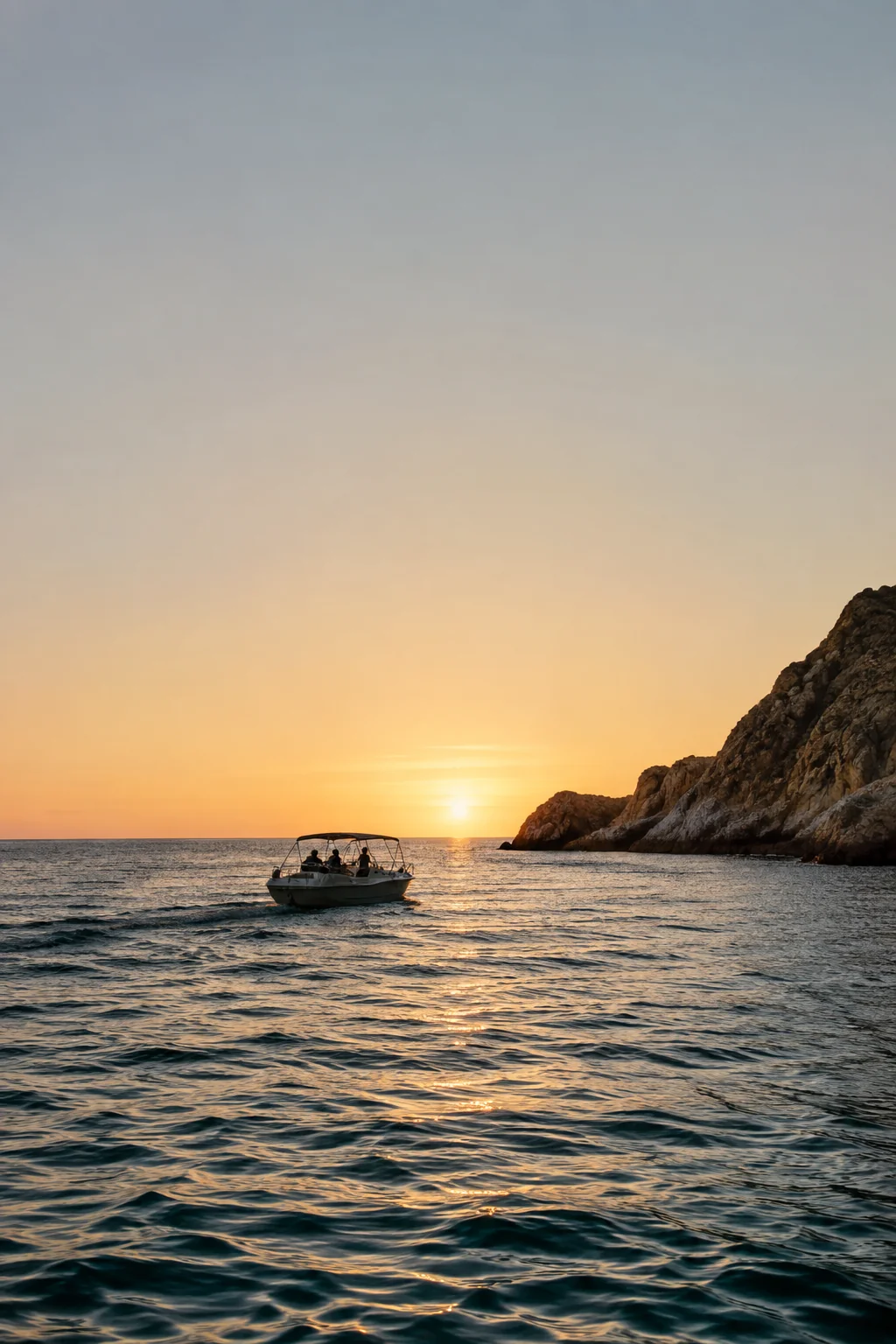 Silueta de una lancha privada navegando hacia el atardecer, cerca de la costa